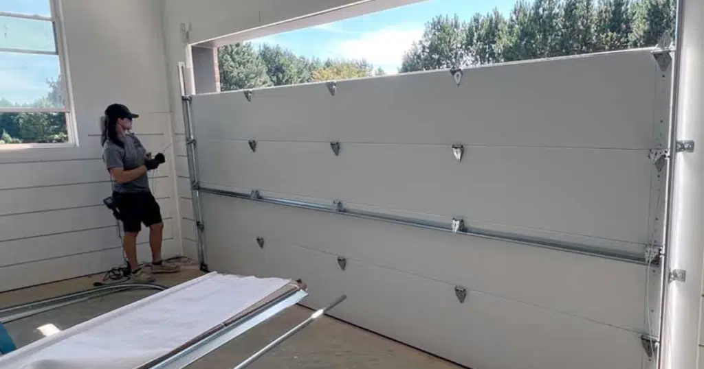 Technician installs new sectional garage door