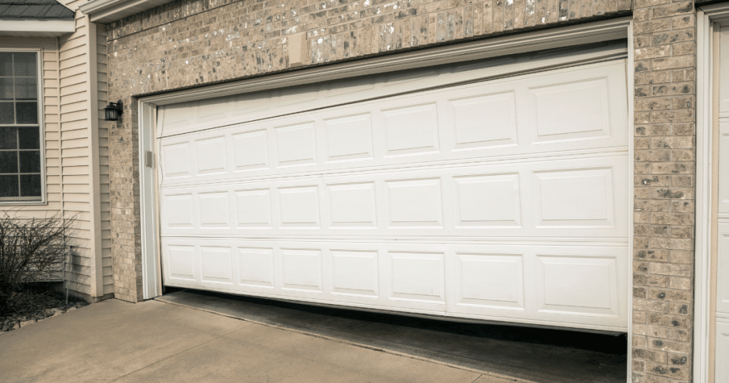 White garage door stuck open, misaligned